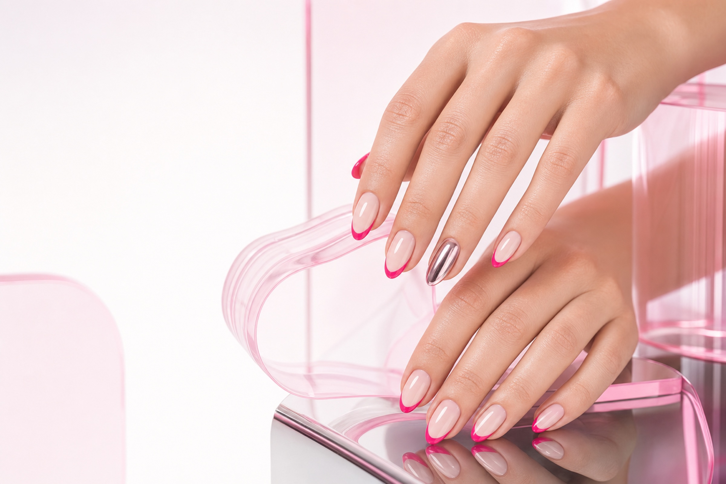 Milky nude nails with electric pink French tips and a chrome accent